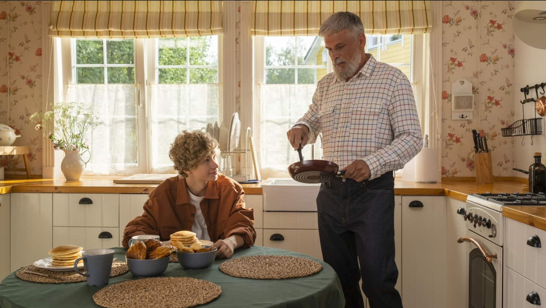 In a cozy home, a man and a Child cook in the kitchen