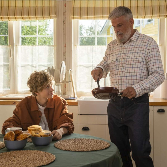 In a cozy home, a man and a Child cook in the kitchen